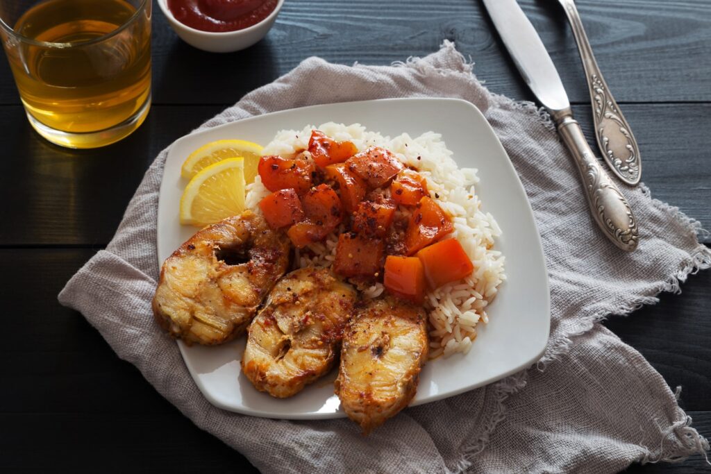 Slices of Fried cod with rice, lemon and pepper